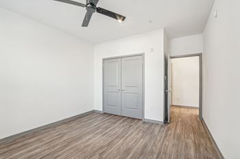 an empty living room with a ceiling fan and a door to a closet at The Maddox Luxury Apartment Homes, Buckeye, AZ, 85326
